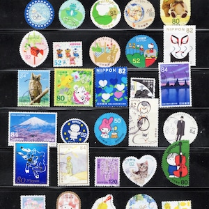 Puede incluir: Una colecci&oacute;n de diversos sellos postales japoneses con ilustraciones variadas que incluyen animales, flores, paisajes y personajes. Los sellos var&iacute;an en forma, incluyendo dise&ntilde;os circulares, rectangulares y en forma de coraz&oacute;n, con denominaciones de 50, 52, 63, 80, 82, 84 y 120.