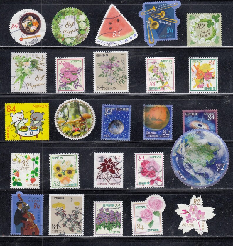 Puede incluir: Una colecci&oacute;n de veinticuatro sellos postales japoneses dispuestos en filas sobre un fondo negro. Los sellos presentan diversas ilustraciones que incluyen flores, una rodaja de sand&iacute;a, instrumentos musicales, im&aacute;genes espaciales y un globo terr&aacute;queo.