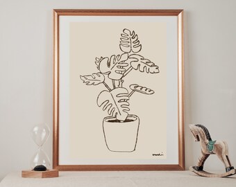 May include: A black and white line drawing of a potted plant with large leaves. The drawing is on a cream background and framed in a gold frame.