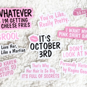 Op de afbeelding: Een verzameling roze en witte stickers met verschillende zinnen en ontwerpen, waaronder "Whatever I'm Getting Cheese Fries", "Grool I Love Her, She's Like a Martian", "It's October 3rd", "You're Like, Really Pretty", "So Fetch", "I Want My Pink Shirt Back!" en "Don't Look At Me".