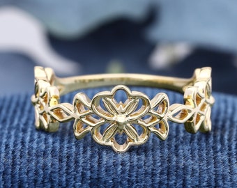 May include: A gold ring with a delicate floral design. The ring is made of three connected flower shapes with intricate cutouts.