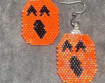 Pendientes colgantes de calabaza de Halloween con cuentas de semillas Miyuki Delica naranjas y negras terminadas con alambre de acero inoxidable en tono plateado.