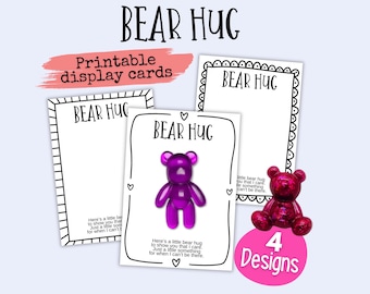 May include: Four printable cards with a black and white border and the text "BEAR HUG" in black. The cards feature a purple and a pink gummy bear with the text "Here's a little bear hug to show you that I care. Just a little something for when I can't be there."