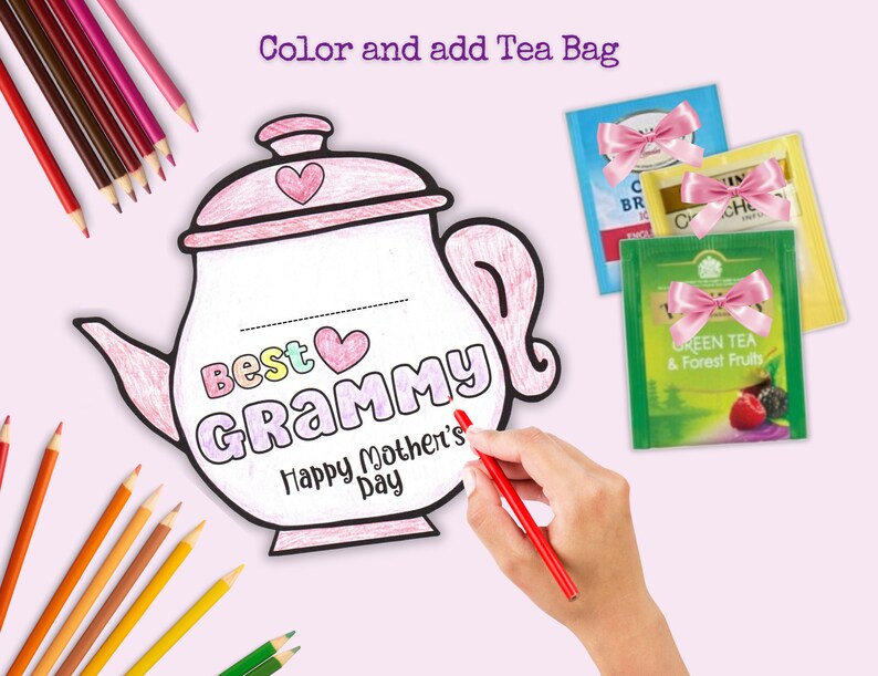 May include: A printable coloring page of a teapot with the words "Best Grammy Happy Mother's Day" on it. The teapot is outlined in black and has a pink heart on the lid. There are also three tea bags with pink bows on them.