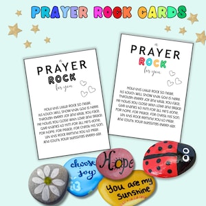 May include: Two white cards with the text "Prayer Rock for You" and a poem, along with painted rocks. The rocks are painted with words like "Hope" and "Sunshine", and a ladybug design. The words "Prayer Rock Cards" are at the top.