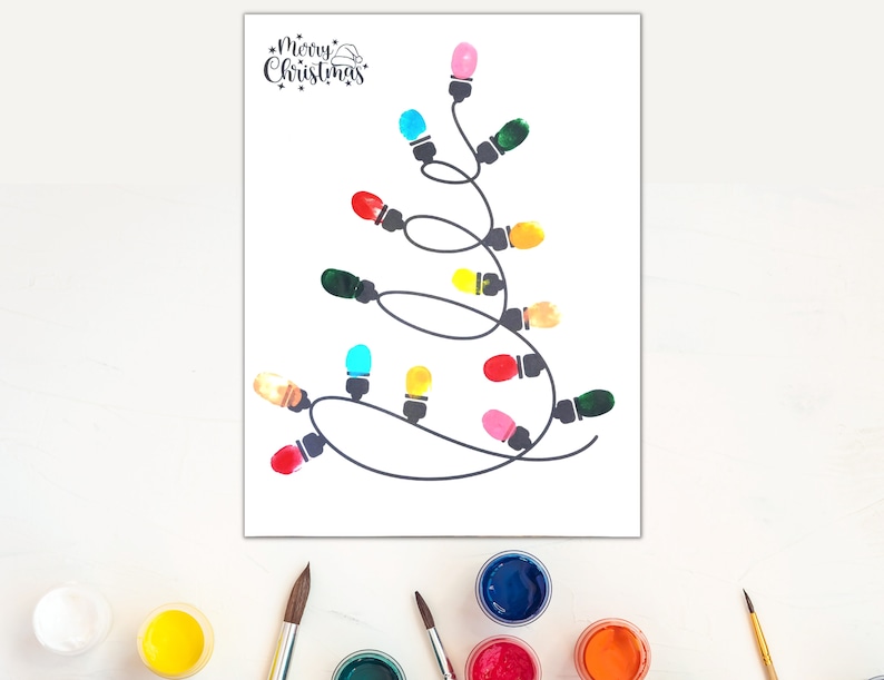 May include: A printable Christmas craft activity for kids. The image shows a black and white outline of a Christmas tree with a string of lights. The lights are to be colored in with finger paints. The text "Merry Christmas" is at the top of the page.