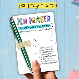 May include: A green pen is taped to a white card with the words "PEN PRAYER" in colorful letters. The card includes text about prayer and encouragement. The words "pen prayer cards" are at the top of the image.