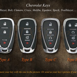 May include: Four different types of Chevrolet car keys, labelled A, B, C, and D. Each key has a black plastic case with silver trim and a red button. The keys have different button arrangements.