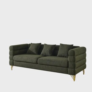 May include: A dark green sofa with three matching throw pillows. The sofa has a textured fabric and a unique arm design. The legs are gold-colored. A modern piece of furniture for a living room or lounge area.
