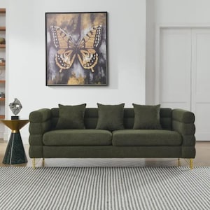 May include: A green sofa with three matching throw pillows and gold-colored legs. A framed butterfly art piece hangs on the wall above the sofa. A small side table with a sculpture is to the left of the sofa.