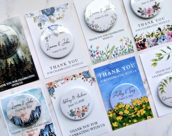 May include: Set of 10 round wedding favor magnets with watercolor designs. Each magnet features a different design with a couple's names and wedding date. The designs include a floral bouquet, a forest scene, and a lemon tree.