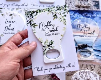May include: White bottle opener favours with a decorative floral design and the names "Mallory & Daniel" and the date "August 22, 2025". The text "Thank you for celebrating with us!" is also printed on the card.