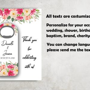 K&ouml;nnte beinhalten: Ein wei&szlig;er Flaschen&ouml;ffner mit floralem Design mit rosa und cremefarbenen Blumen. Der &Ouml;ffner tr&auml;gt die Namen "Danielle & Jenica" und das Datum "03. AUGUST 2026". Der Text lautet "Vielen Dank, dass Sie mit uns feiern!" und "Alle Texte sind anpassbar".
