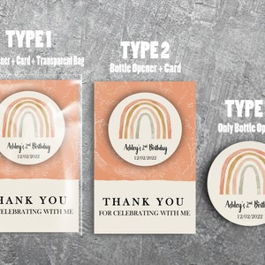 May include: Three different types of party favors featuring a watercolor rainbow design with the text "Ashley's 2nd Birthday 12/02/2022". The first option includes a bottle opener, card, and a transparent bag. The second option includes a bottle opener and card. The third option is just a bottle opener.