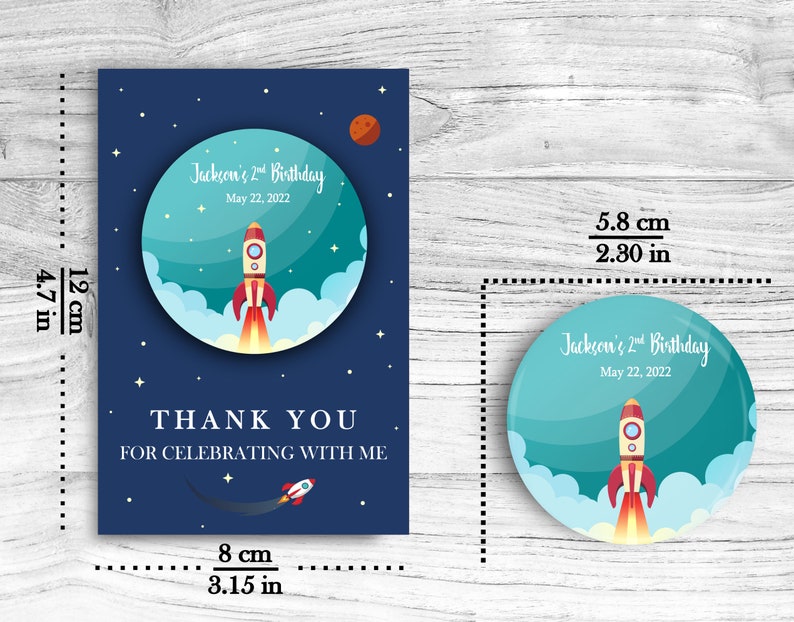 May include: A blue and teal thank you card with a rocket ship and stars. The card reads "Jackson's 2nd Birthday" and "Thank you for celebrating with me". The card measures 4.7 inches by 3.15 inches.