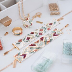 May include: A collection of handmade beaded jewelry, including two white bracelets with floral patterns in red, green, and gold beads. A matching ring and necklace are also visible, along with containers of beads and jewelry-making supplies.