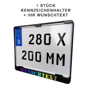 Könnte beinhalten: Schwarzer Kennzeichenhalter mit weißem Hintergrund. Der Halter ist 280 x 200 mm groß und bietet Platz für ein Kennzeichen und einen Wunschtext. Der Text "WUNSCHTEXT" ist in Regenbogenfarben am unteren Rand des Halters aufgedruckt.
