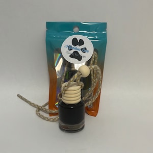 May include: A black glass bottle with a wooden cap and a gold and white string attached. The bottle is labeled "A Golden Love Black Ice Type".