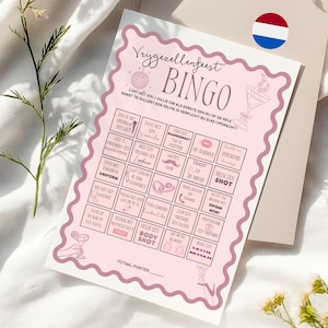 Op de afbeelding: Een roze en witte bruiloftsshower bingo kaart met een roze en witte discobal, een roze en witte cocktailglas en een roze en witte lippenstift. De kaart heeft een verscheidenheid aan vakjes met verschillende activiteiten, zoals "Zing een liedje", "Neem een shot" en "Dans met de bruid".