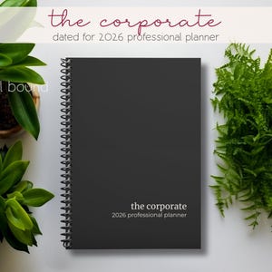 May include: A black spiral-bound planner titled "the corporate" dated for 2026. The cover is plain with the title and year printed in white. Green plants surround the planner on a white surface.