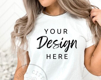 May include: A white t-shirt with the text "YOUR Design HERE" in black script font.