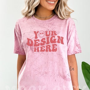 Puede incluir: Una camiseta rosa tie-dye con el texto "YOUR DESIGN HERE" en rojo con una carita sonriente.
