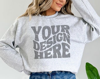 Puede incluir: Una sudadera gris con un gráfico de estilo vintage que dice "YOUR DESIGN HERE" en gris.