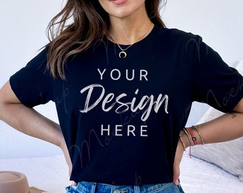 May include: A black t-shirt with the text "YOUR Design HERE" in white lettering. The shirt is being worn by a person with long brown hair and blue jeans.