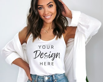 Pode incluir: Um top branco sem mangas com o texto "YOUR Design HERE" estampado na frente. O top está sendo usado por uma pessoa com cabelo castanho longo e é combinado com shorts jeans e um cardigã branco.