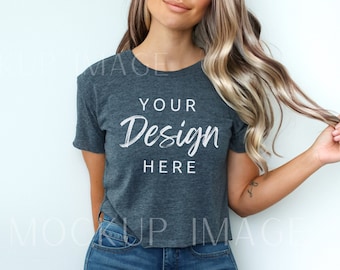May include: A woman wearing a heather gray cropped t-shirt with the text "YOUR Design HERE" printed on the front. She is wearing blue jeans and has long blonde hair.