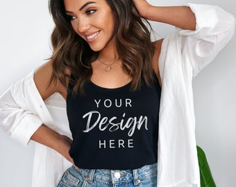 May include: Black tank top with the text "YOUR Design HERE". The tank top is paired with denim shorts and a white button-down shirt. The model is wearing a gold necklace.