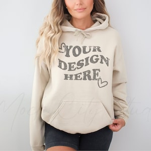 May include: A beige hoodie with a large gray graphic that says "YOUR DESIGN HERE" with a small heart on either side of the text.