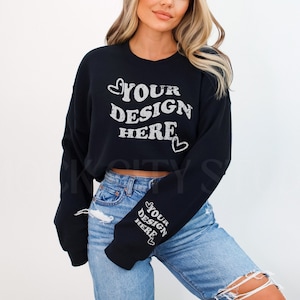 Może przedstawiać: Czarny, krótki sweter z długimi rękawami i nadrukiem "YOUR DESIGN HERE" z przodu. Sweter ma biały wzór serca z przodu i napis "YOUR DESIGN HERE" nadrukowany na rękawie.