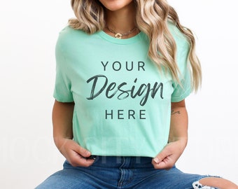 Puede incluir: Una mujer con una camiseta verde claro con el texto "YOUR Design HERE" impreso en la parte delantera. Lleva pantalones vaqueros azules y tiene el pelo largo y rubio.