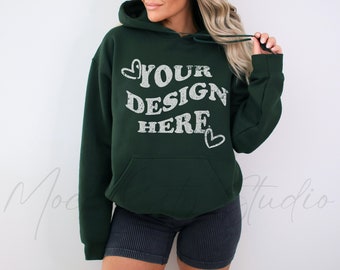 May include: A dark green hooded sweatshirt with the text "YOUR DESIGN HERE" in white lettering with a distressed look. The text is surrounded by two small white hearts.