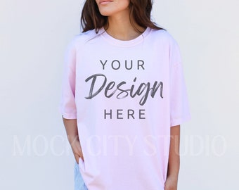 May include: A pink oversized t-shirt with the text "YOUR Design HERE" printed on the front.