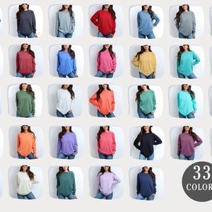 May include: A grid of 33 different colored long-sleeve shirts. The shirts are all the same style and fit, but they are shown in a variety of colors, including red, blue, green, yellow, and purple. The text "33 COLORS" is displayed in the bottom right corner of the image.