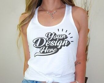 Puede incluir: Camiseta blanca de tirantes con el texto "Your Design Here" en una fuente retro negra.