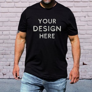 May include: A black t-shirt with the text "YOUR DESIGN HERE" printed on the front.