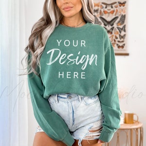 May include: A green, long-sleeved, cropped sweatshirt with the text "YOUR Design HERE" in white.