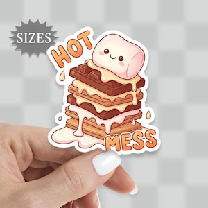 May include: A sticker featuring a cartoon s'more with a smiling marshmallow on top. The words "HOT MESS" are written in orange, and the word "SIZES" is in a gray starburst shape. The s'more has layers of chocolate, graham crackers, and melted marshmallow.