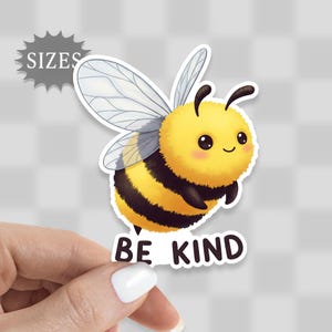 May include: A yellow and black cartoon bee with a fuzzy body and large eyes. The bee has a white and gray wing and is flying. The text "Be Kind" is below the bee.
