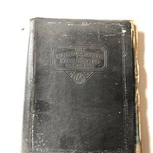 Op de afbeelding: Een zwart lederen gebonden boek met de titel "The Electric Controller & Manufacturing Co. Cleveland, Ohio" op de voorzijde.