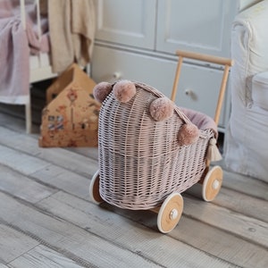 LittleDreamsShopPL Rieten & houten poppenwagen in stoffig roze beddengoed en pompons afbeelding 1