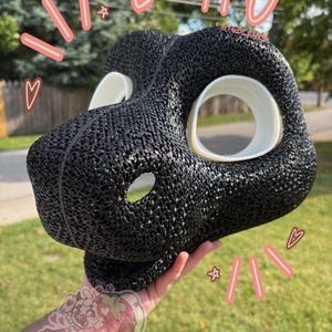 May include: A black 3D printed TPU animal mask base featuring a textured, porous surface and white circular eye blanks. The mask has a snout with a central opening and is marked with the text 11% TPU + EYEBLANKS in pink handwritten style.