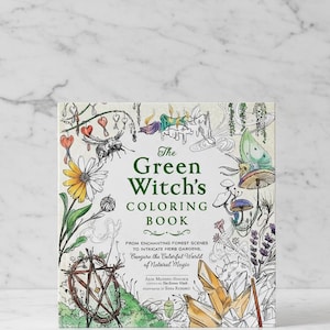 Könnte beinhalten: Ein quadratisches Malbuch mit dem Titel "The Green Witch's Coloring Book". Das Cover zeigt skurrile Illustrationen von Pflanzen, Insekten und Kristallen. Der Untertitel des Buches lautet: "From Enchanting Forest Scenes to Intricate Herb Gardens."