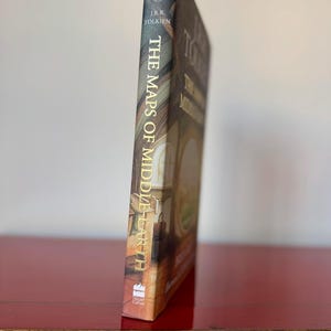 May include: A set of three ceramic mugs with a speckled, matte finish. The mugs are in shades of cream, light gray, and dark gray. Each mug has a simple, minimalist design and a rounded handle.