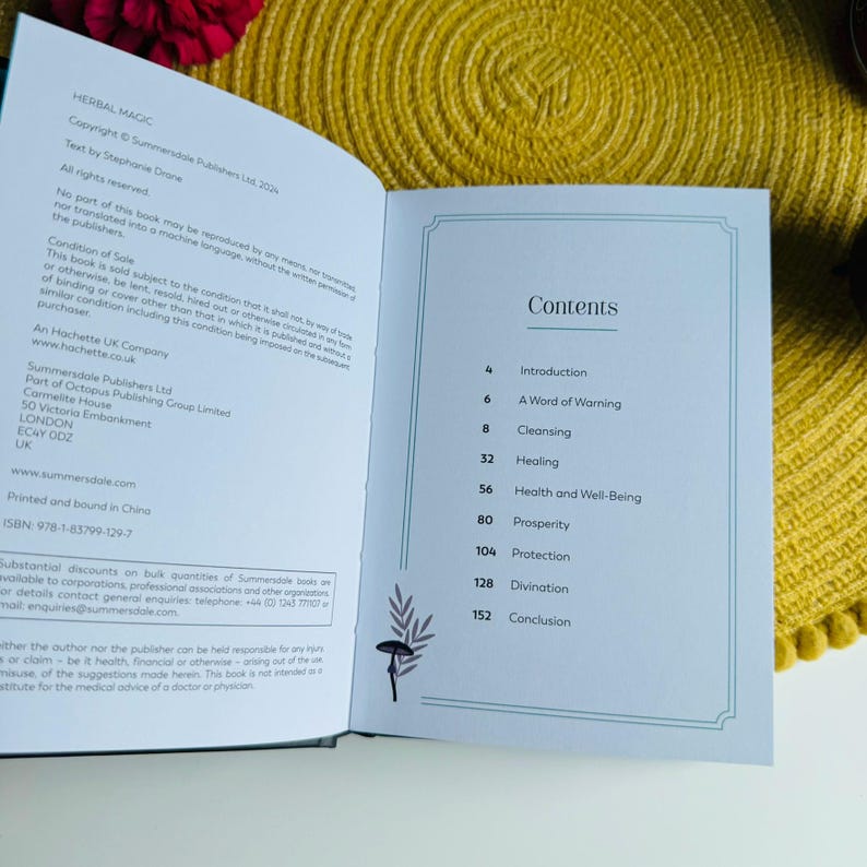 May include: An open book with a blue cover and white pages. The title of the book is "Herbal Magic" and the contents page is visible. The contents page lists topics such as Introduction, A Word of Warning, Cleansing, Healing, Health and Well-Being, Prosperity, Protection, Divination, and Conclusion.