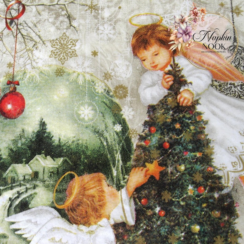May include: Two angels decorate a Christmas tree with red ornaments and a gold star. The tree is surrounded by a snowy winter scene with a small village in the background. The image is from Napkin Nook decoupage papers.