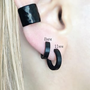 May include: Black ear cuff and hoop earrings. The ear cuff has a textured surface. The hoop earrings are 8mm and 11mm in size. The word "BLACK" is printed at the bottom of the image.